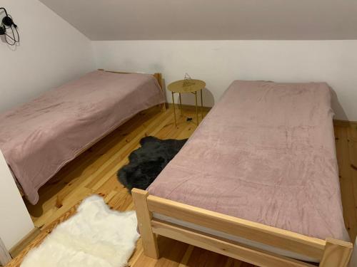 a bedroom with two beds and a wooden floor at Domki nad stawem nr2 in Majdan Nowy