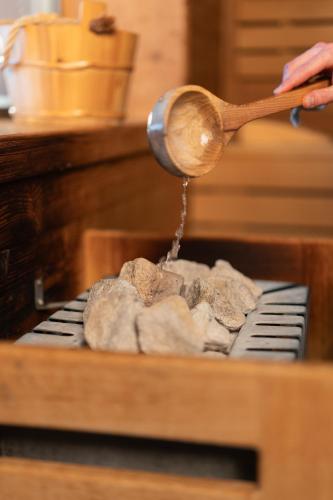 a person is cooking food with a wooden spoon at Berghotel Zorzi in Alpe di Siusi