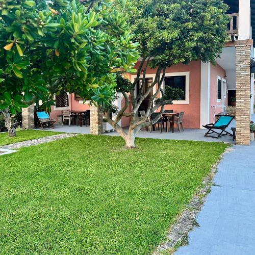 a tree in a yard next to a house at Genari Beach Apartments -Family sea view apartment in Korakokhórion