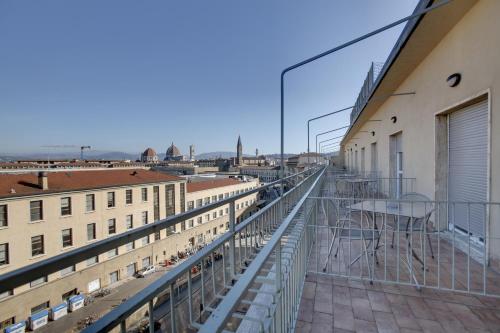 a balcony with tables and chairs on a building at Hotel Delle Nazioni in Florence