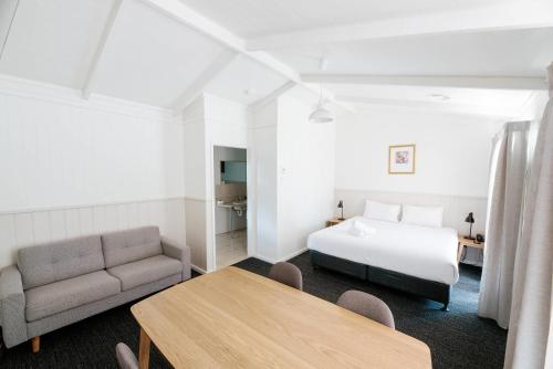 a hotel room with a bed and a couch and a table at Quality Hotel Lakeside in Bendigo