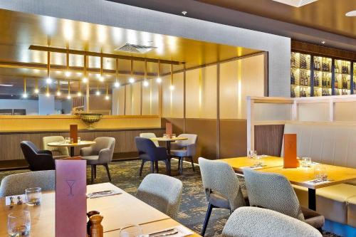 a restaurant with tables and chairs and a bar at Quality Hotel Lakeside in Bendigo