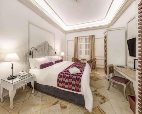 a hotel room with a large bed and a desk at Hotel Caribe by Faranda Grand, a member of Radisson Individuals in Cartagena de Indias