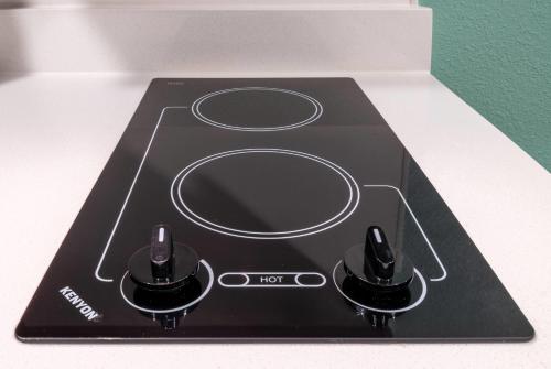 a black stove top with two knobs on it at ECHO Suites Extended Stay by Wyndham Houston Pasadena Fwy Pl in Pasadena