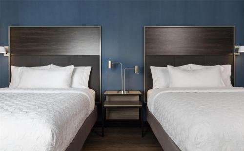 two beds sitting next to each other in a bedroom at Tru By Hilton Montréal centre-ville in Montréal