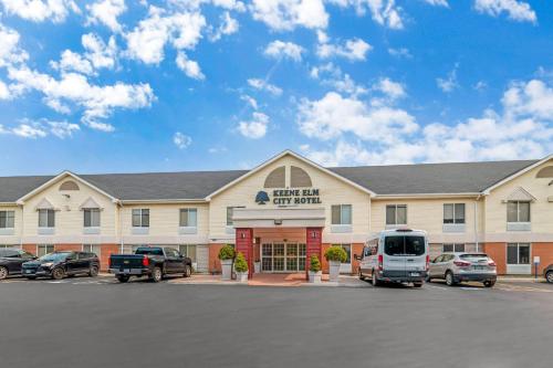 a large building with cars parked in a parking lot at Keene Elm City Hotel, an Ascend Collection Hotel in Keene