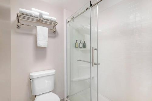 a white bathroom with a shower and a toilet at Keene Elm City Hotel, an Ascend Collection Hotel in Keene