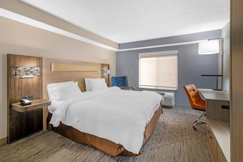 a hotel room with a large bed and a desk at Keene Elm City Hotel, an Ascend Collection Hotel in Keene