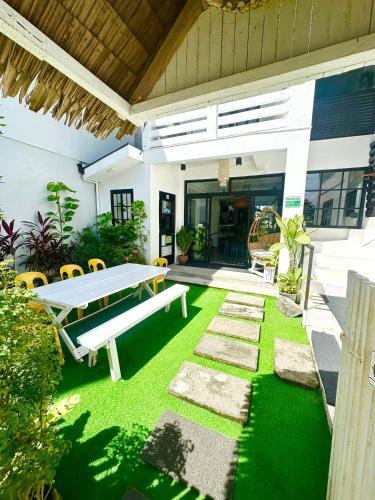 a backyard with a picnic table and green grass at BACKDOOR VILLA in Baler