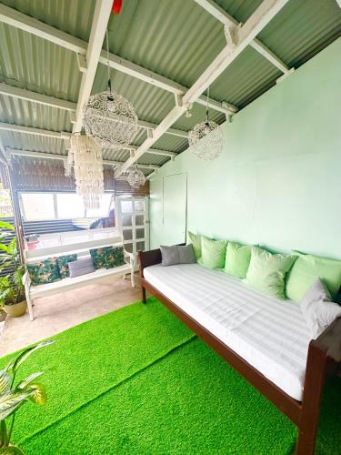 a living room with a bed with a green rug at BACKDOOR VILLA in Baler