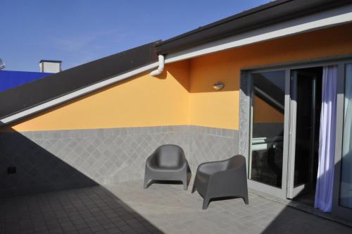 two chairs sitting on a patio next to a building at Hotel Motel 2 in Tortona