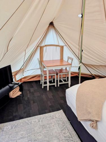a tent with a table and chairs in a room at Stargazers Forest Hideaway Pemberton in Peerabeelup