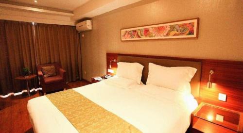 a hotel room with a white bed and a chair at Yitel Collection Lianyungang High-speed Railway Station Suning Plaza in Lianyungang