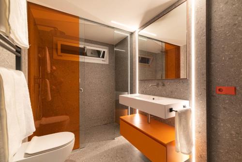 a bathroom with a sink and a toilet and a mirror at Suite Deluxe Samil in Vilamar