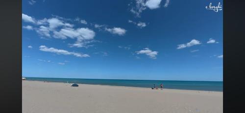 a group of people walking on a beach at B&B Planet in Montalbano Jonico