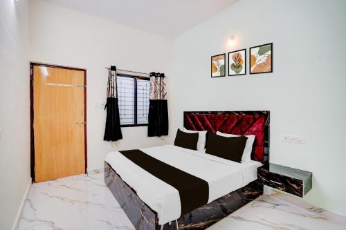 a bedroom with a large bed and a wooden door at SPOT ON Hotel Royal Inn in Chandrapur