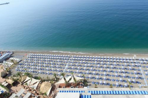 an aerial view of a beach with lots of umbrellas at Lloyd's Baia Hotel in Vietri sul Mare