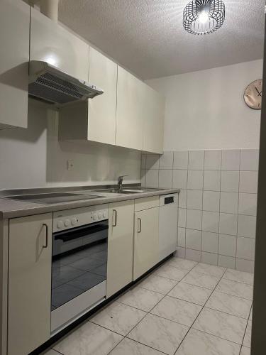 a kitchen with white cabinets and a stove top oven at Central Hideaway Garden, Parking, Cinema,4,5rooms in Zürich
