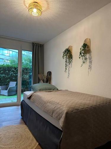 a bedroom with a bed and a large window at Central Hideaway Garden, Parking, Cinema,4,5rooms in Zürich