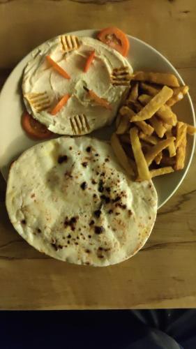 un plato de comida con un sándwich y papas fritas en Krepodas Retreat House, en Rishīkesh