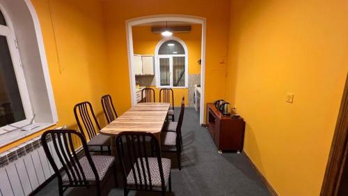 バクーにあるBaku Smile Hostelの黄色の壁のダイニングルーム(テーブル、椅子付)