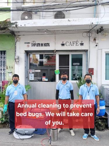 a group of men standing in front of a building holding a sign at Sleepwith me Hostel in Bangkok