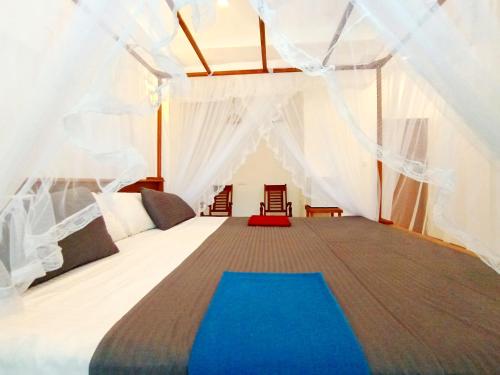 a bedroom with a large bed in a tent at Minuda Villa in Kamburugamuwa