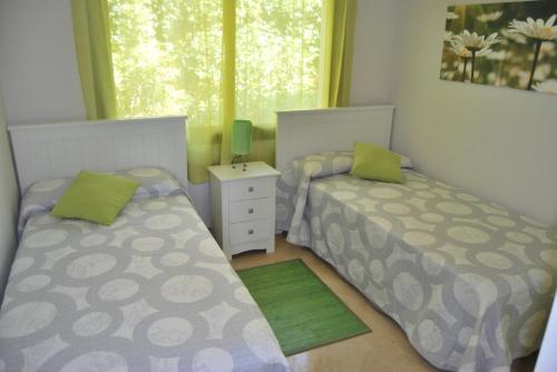 アルカイデサにあるApartamento Marina de la Alcaidesaのベッドルーム1室(ベッド2台、窓付)