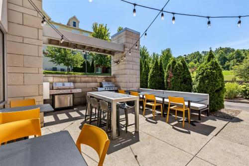 a patio with tables and chairs and a grill at Home2 Suites By Hilton Youngstown in Youngstown