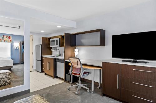 a hotel room with a desk with a television and a bed at Home2 Suites By Hilton Youngstown in Youngstown