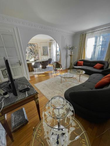 a living room with a couch and a table at Tour Eiffel - Grand appartement 2 chambres 110m2 in Paris