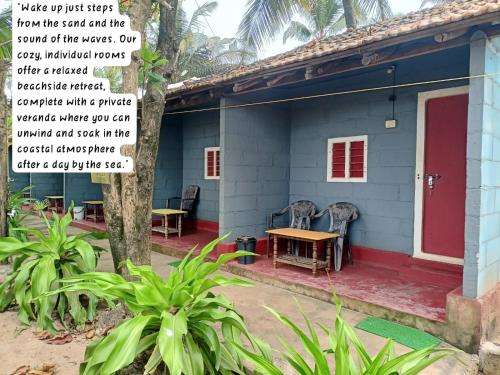 a blue house with a red door and a table at Prakruti Gokarna in Jāmb