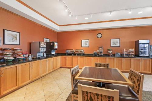 een eetkamer met een tafel en een keuken bij MainStay Suites Stanley in Stanley