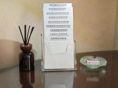 a glass table with a box and a vase on it at Chinflux Mandarin Hotel in Dongguan