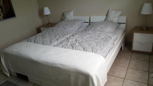 a bedroom with a bed with white sheets and pillows at Ferienwohnung Jürgens in Rheinbreitbach