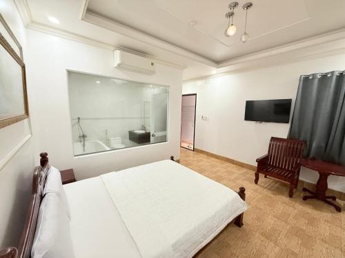a bedroom with a bed and a desk and a television at Hotel 5 Sao in Bến Lức