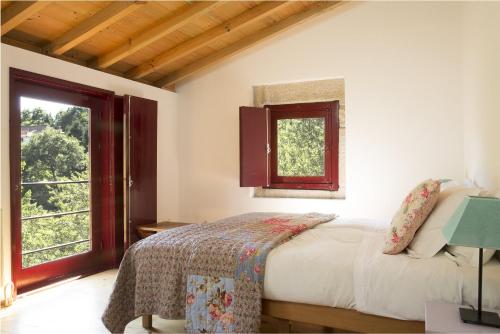 a bedroom with a bed and a window at Casa Agricola da Levada Eco Village in Vila Real