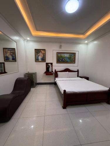 a bedroom with a bed and a couch in it at Hotel 5 Sao in Bến Lức