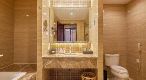 a bathroom with a sink and a toilet and a mirror at Huangshan International Hotel in Huangshan