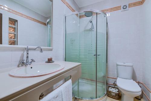 a bathroom with a shower and a sink and a toilet at Espargosa Monte de Baixo & Art in Castro Marim