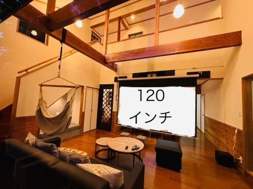 a large screen in a living room with a tv at Villa Foresta Sora in Nasushiobara