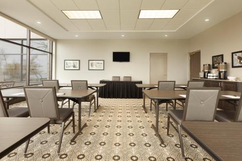 a dining room with tables and chairs and a tv at Country Inn & Suites by Radisson, Bemidji, MN in Bemidji