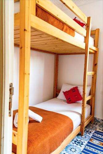 a bedroom with two bunk beds in a room at Aourir Waves Surf House in Aourir