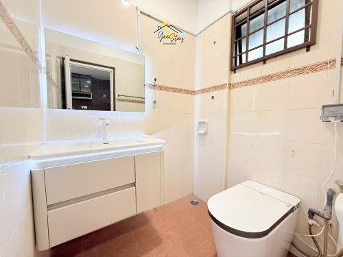 a bathroom with a toilet and a sink and a mirror at UjongPasir18paxLanded10minstoJonker in Melaka