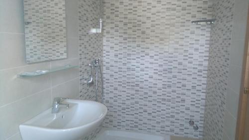 a white bathroom with a sink and a shower at Pensione Afrodite in Metaponto