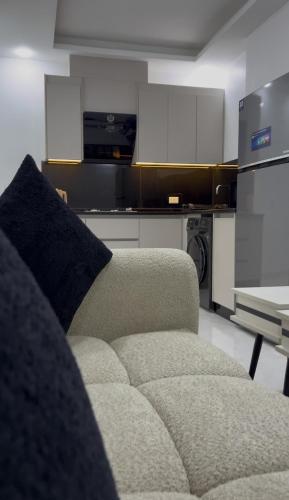 a living room with a couch and a kitchen at Luxury furnished apartment in Irbid