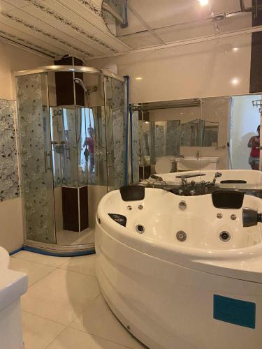 a white bath tub in a room with a shower at Precious Ruby's Apartment in Manila