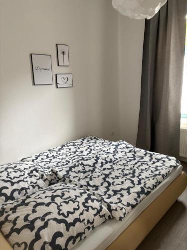 a bedroom with a bed with a black and white blanket at Wohnung am Auepark in Kassel