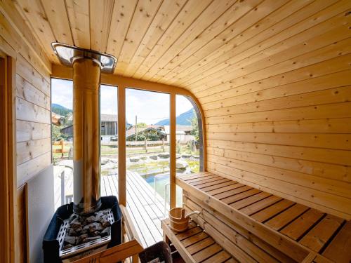 a wooden sauna with a stove on a deck at Farmhouse in Bramberg with Natural Pond in Dorf