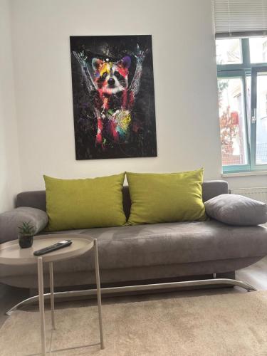 a couch in a living room with a painting of a dog at Wohnung am Auepark in Kassel